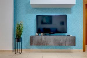 a flat screen tv sitting on a blue wall at Sliema Tigne Suites in Sliema