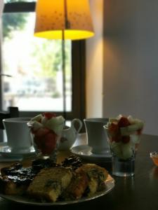 a table with a plate of food and cups and a lamp at Agriturismo La Fattoria Del Boschetto in Fontanellato