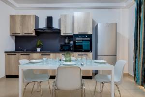 a kitchen with a white table and white chairs at Sliema Tigne Suites in Sliema