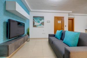 a living room with a couch and a flat screen tv at Sliema Tigne Suites in Sliema