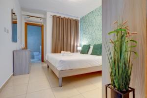a bedroom with a bed and a bathroom at Sliema Tigne Suites in Sliema