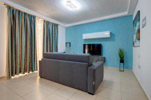 a living room with a couch and a blue wall at Sliema Tigne Suites in Sliema