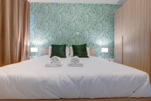 a bedroom with a white bed with towels on it at Sliema Tigne Suites in Sliema
