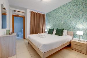 a bedroom with a large bed and a bathroom at Sliema Tigne Suites in Sliema