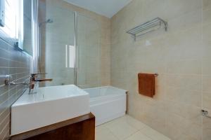 a bathroom with a white sink and a shower at Sliema Tigne Suites in Sliema