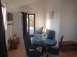 ein Wohnzimmer mit einem Tisch und einem Sofa in der Unterkunft Apartmani Zdenka Savar-Maslina in Savar
