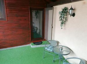 un patio con una mesa de cristal y sillas en un porche en Cozy attic studio en Brasov