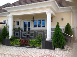a white house with a gate and columns at Blue-View Suites & Apartments in Abuja
