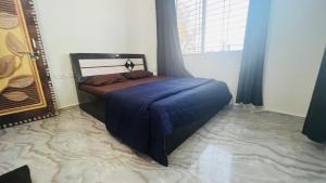 a bedroom with a bed with a blue blanket at Blue House Karjat Cottage in Chinchavli