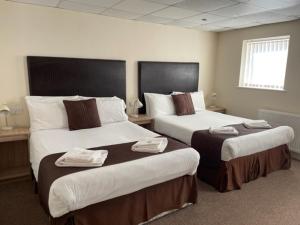 a hotel room with two beds with towels on them at Stuart hotel in Blackpool