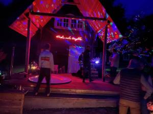 een groep mensen die 's nachts op een podium staan bij Holiday homestead Camp of Forest Souls 
