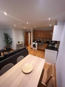 ein Wohnzimmer mit einem Sofa und einem Tisch sowie eine Küche in der Unterkunft Spacious 1 bedroom flat in Marylebone in London