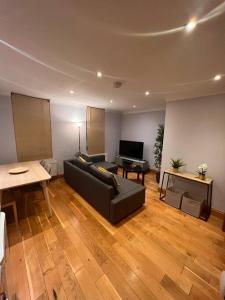 ein Wohnzimmer mit einem schwarzen Sofa und einem Klavier in der Unterkunft Spacious 1 bedroom flat in Marylebone in London