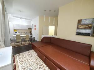 Il comprend un salon avec un canapé brun et une cuisine. dans l'établissement Central Good Apartments in the Chisinau, à Chişinău