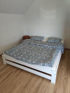 Cama pequeña en habitación con suelo de madera en Apartament za lasem, en Kaliska Kośierskie