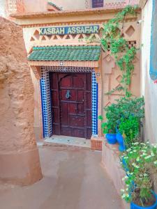 wejście do budynku z drewnianymi drzwiami w obiekcie Kasbah Assafar w mieście Kalaat M'Gouna