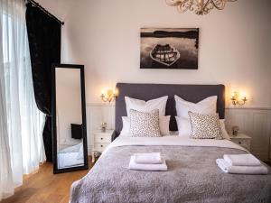 een slaapkamer met een groot bed en een spiegel bij Elegant Hvar town villa with pool in Hvar +69 foto's