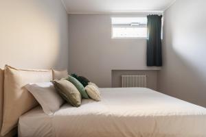 Un dormitorio con una cama con almohadas. en easyhomes - Botta, en Milán