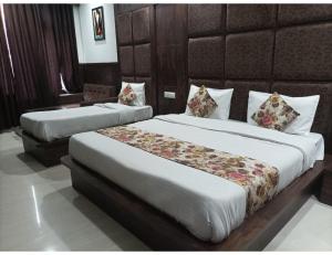 two beds in a hotel room with two beds at Hotel Virat International AVR Shopping, Katra in Katra
