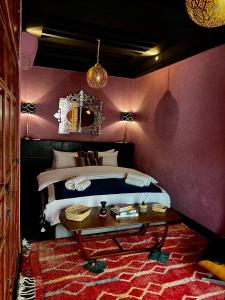 a bedroom with a large bed and a table at Riad Alena in Marrakesh