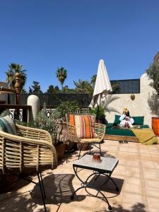 a patio with rattan chairs and a table at Riad Alena in Marrakech