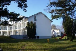 a large white house with a slide in the yard at Villa Granitz - Ferienwohnung Riedel in Göhren