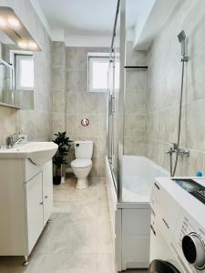 uma casa de banho com um lavatório, um WC e uma banheira em Altheda Living Brownie 29E-2 em Suceava