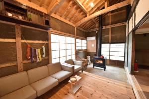 Una sala de estar con un sofá y una estufa. en Dive INN Kiryu, en Kiryu