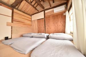 a row of beds in a room with wooden walls at Dive INN Kiryu in Kiryu