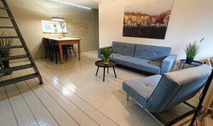 een woonkamer met een blauwe bank en een tafel bij De Fluessen Loft in Elahuizen