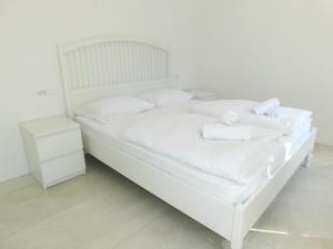 Cama blanca con sábanas blancas y almohadas blancas en Cankar's secret place, en Liubliana