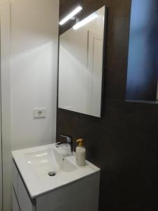 y baño con lavabo blanco y espejo. en Cankar's secret place, en Liubliana