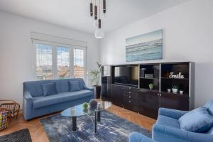 uma sala de estar com dois sofás azuis e uma televisão em Apartment Blue em Stobreč