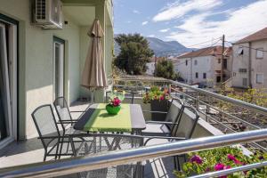 a balcony with a table and chairs and an umbrella at Apartment Blue in Stobreč