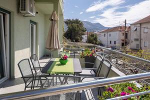 uma varanda com uma mesa e cadeiras e um guarda-sol em Apartment Blue em Stobreč