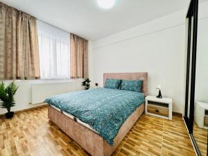 um quarto com uma cama com um edredão azul em Altheda Living Brownie 29E-2 em Suceava
