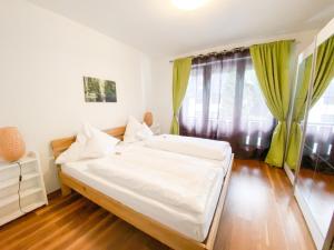 Un dormitorio con una gran cama blanca y una ventana. en Ferienwohnung Hochfirstblick, en Titisee-Neustadt
