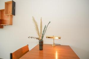 a wooden table with a vase with a plant in it at Stylish apartment with free BaselCard in Basel