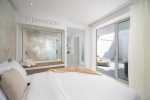a bedroom with a bed and a view of a bathroom at Cycladic Suites in Fira