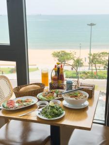 a table with plates of food and a view of the ocean at HAKU Boutique Hotel in Quy Nhon