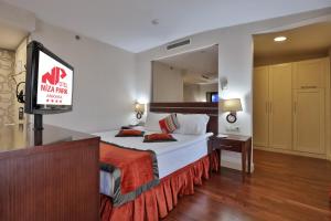 アンカラにあるニザ パーク ホテルのベッドとテレビ付きのホテルルーム