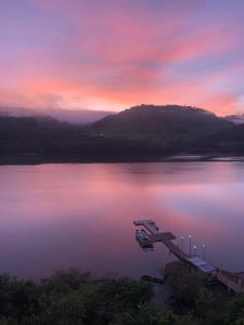 a view of a lake at sunset with a dock at Solar das Águas - HOTEL in Marcelino Ramos