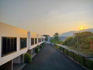 カンチャナブリにあるCicada Hotel Kanchanaburiの夕日を背景にした建物の景色