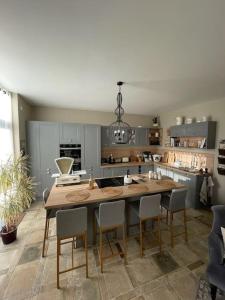 una cocina con una gran mesa de madera y sillas en Le pigeonnier / Gîte de charme 1 à 4 pers 80 m², en Cambrai