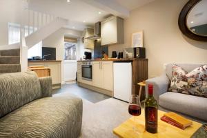 a living room with a couch and a table with a bottle of wine at Garn Yam Cottage in Ambleside +14 photos