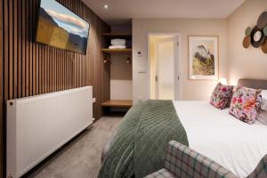 a bedroom with a bed and a chair in it at Garn Yam Cottage in Ambleside