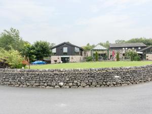 a stone retaining wall in front of a house at Chalet No 2 in Skipton