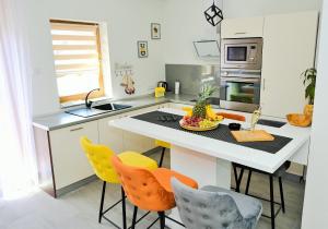 a kitchen with yellow chairs and a white counter top at Lola's House in Jajce