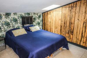 a bedroom with a blue bed with wooden walls at CASA JUNGLE ! Superb duplex apartment, Place des LICES ! in Saint-Tropez