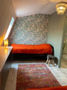1 dormitorio con cama roja y pared en Unieke woonark met privétuin en free parking. en Róterdam